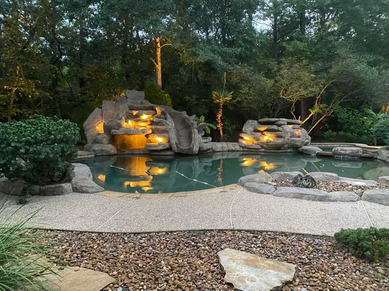 backyard pool with lights in the rock waterfall
