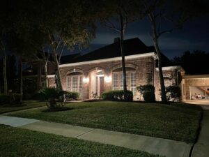 Red brick home lit up by outdoor lighting