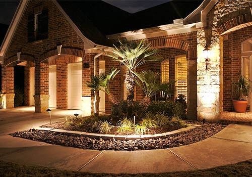 accent lighting around a flower bed in front of a home