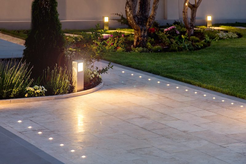marble tile playground in the night backyard of mansion with flowerbeds and lawn